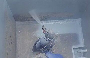 صورة لرجل يقوم بعزل خزان مياه من الداخل والخارج باستخدام مادة البولي يوريا